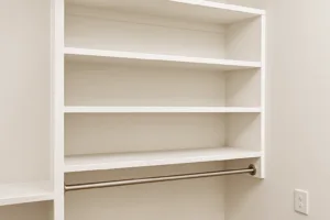 Custom-built white closet shelves installed along a wall, featuring clean lines, adjustable supports, and organized storage bins — ideal for DIY home organization projects.